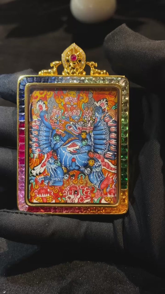 Close-up video of 18K gold double-sided hand-painted Yamantaka and Yellow Jambhala thangka pendant, showing Rebgong master-level details, Gau box, sapphire crystal, and gemstone inlay