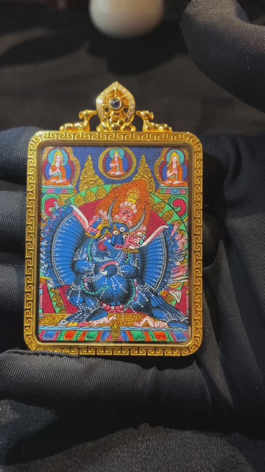 Close-up video of 18K gold double-sided hand-painted Yamantaka and Black Jambhala thangka pendant, showing Rebgong master-level details, dual-wear design, Gau box, and sapphire crystal