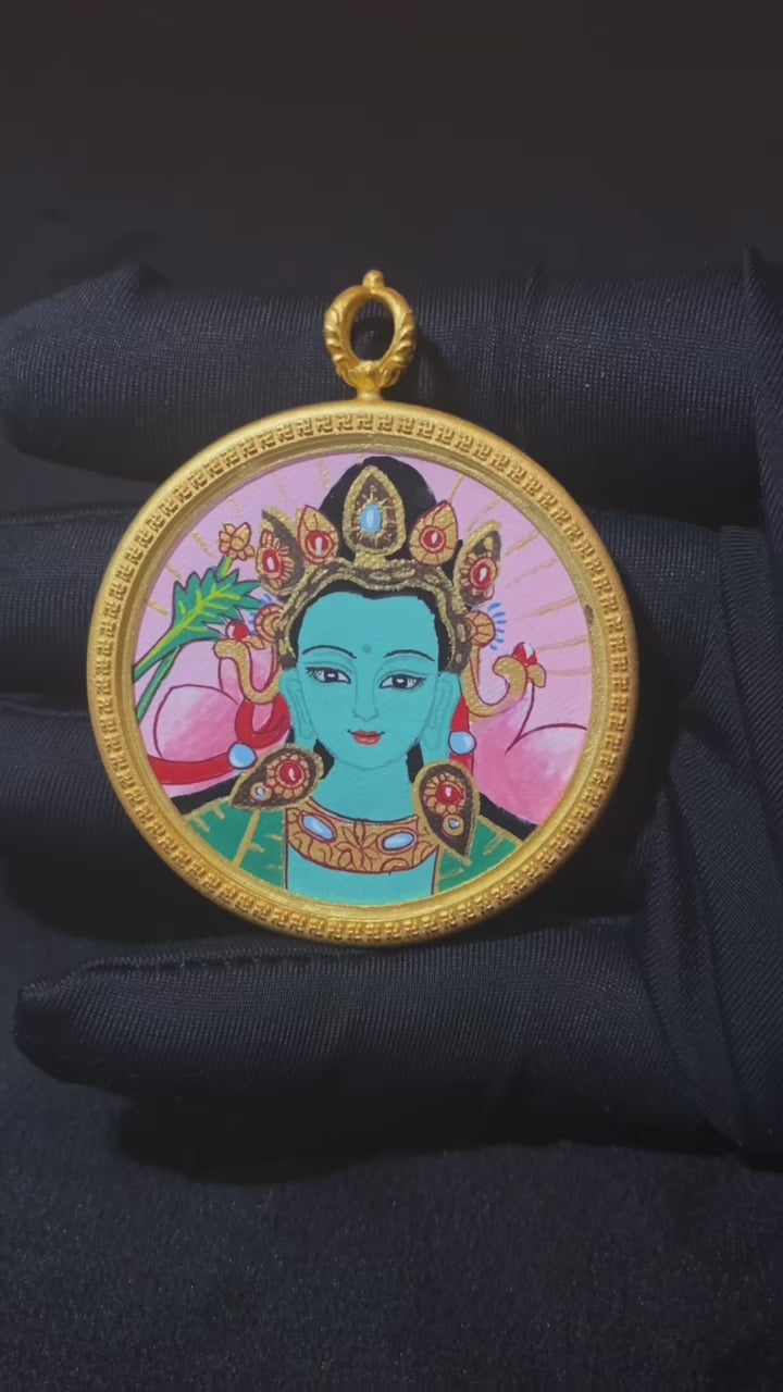 Video showcasing a hand-painted Green Tara thangka pendant in a round copper Ghau box, highlighting the front portrait and symbolic back design