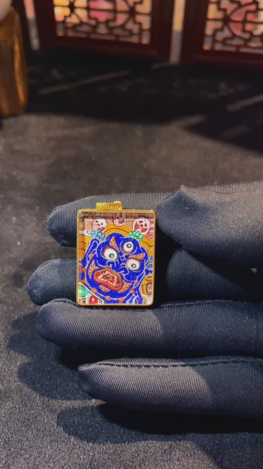 Close-up video of Mahakala thangka pendant hand-painted in 18K gold, showing double-sided Rebgong artwork, Gau box details, and sapphire crystal protection