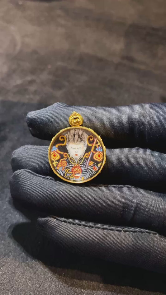 Close-up video of a Guanyin and Victorious Fighting Buddha Thangka pendant, double-sided hand-painted in 18K gold, crafted in Rebgong style and set in a sapphire-lens Gawu box
