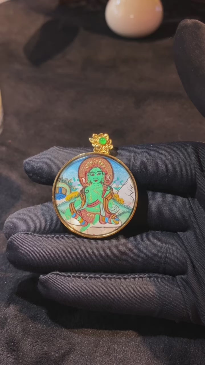 Product video showcasing a round Green Tara Thangka pendant, hand-painted with 18K gold in Rebgong tradition and housed in an 18K gold Gau box with sapphire crystal cover.
