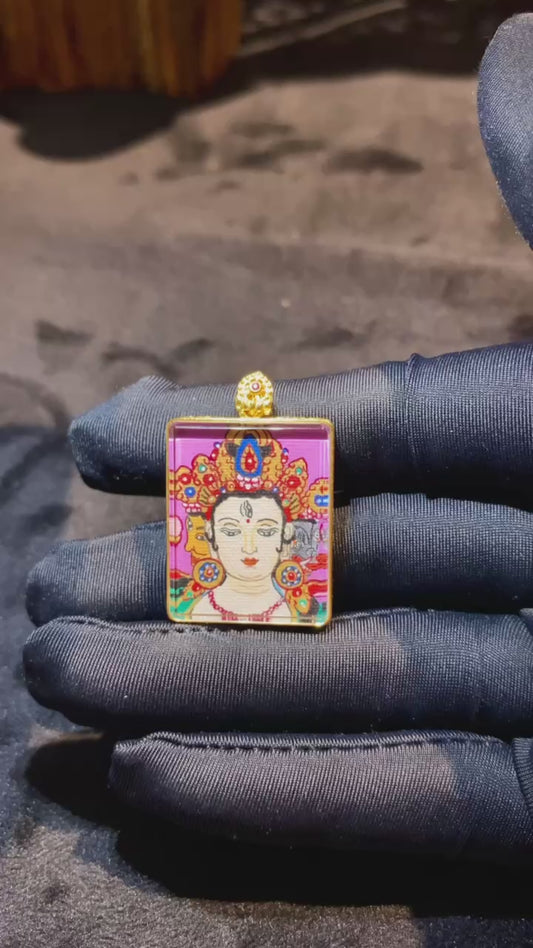 Close-up video of a Marici Devi Thangka pendant with bow-and-arrow symbolism, double-sided hand-painted in 18K gold, crafted in Rebgong style and set in a sapphire-lens Gawu box