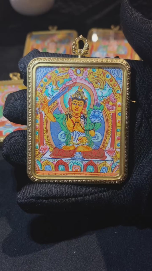Video showcasing a hand-painted Green Tara thangka pendant in a titanium steel Ghau box, highlighting the full seated image and symbolic back engraving