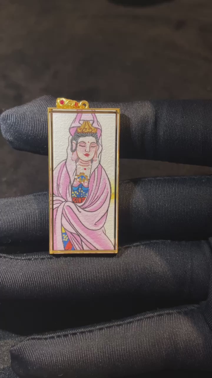 Close-up video of an Avalokiteshvara Guanyin Thangka pendant, double-sided hand-painted in 18K gold, featuring a golden lotus and crafted in Rebgong style, guardian for Rat, Cancer, and Capricorn