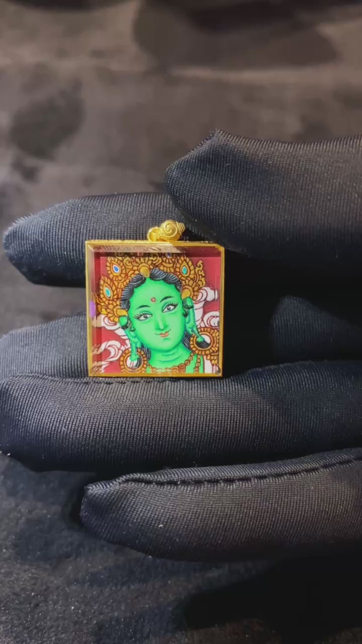 Video showcasing a hand-painted Green Tara Gau Thangka pendant with Green Tara on the front and five sacred scriptures on the back, crafted in an 18K gold case with sapphire crystal protection