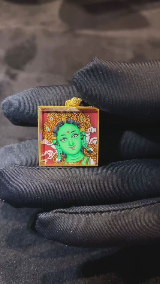 Video showcasing a hand-painted Green Tara Gau Thangka pendant with Green Tara on the front and five sacred scriptures on the back, crafted in an 18K gold case with sapphire crystal protection