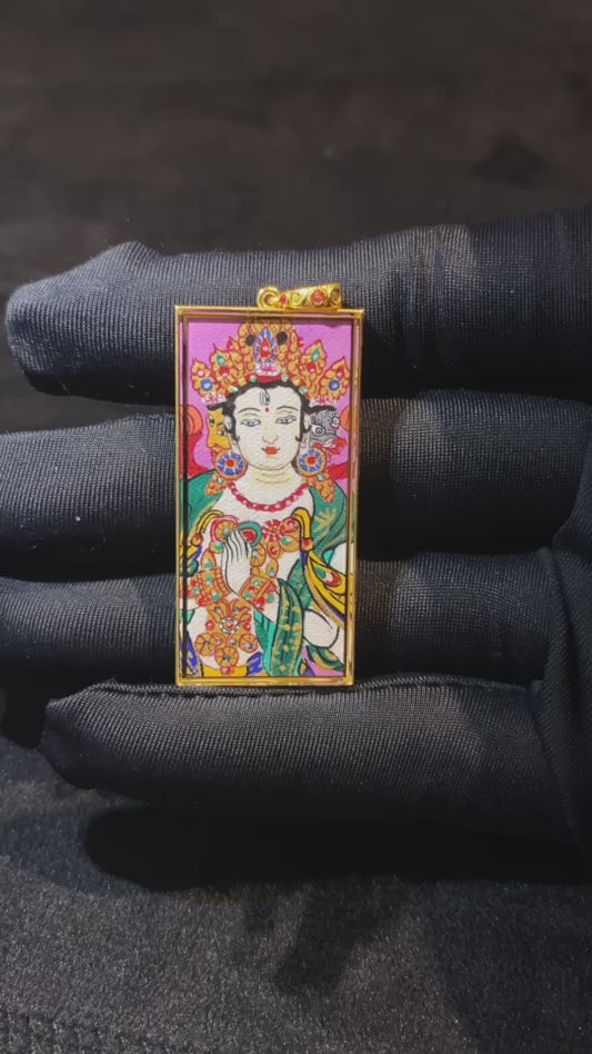 Close-up video of a Marici Devi Thangka pendant with six-syllable mantra, double-sided hand-painted in 18K gold, crafted in Rebgong style and set in a sapphire-lens Gawu box