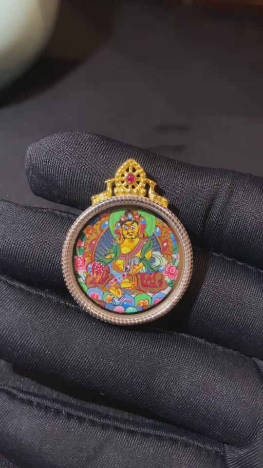 video of hand-painted Yellow Jambhala Thangka set in an S925 sterling silver Tibetan Gawu pendant, God of Wealth amulet