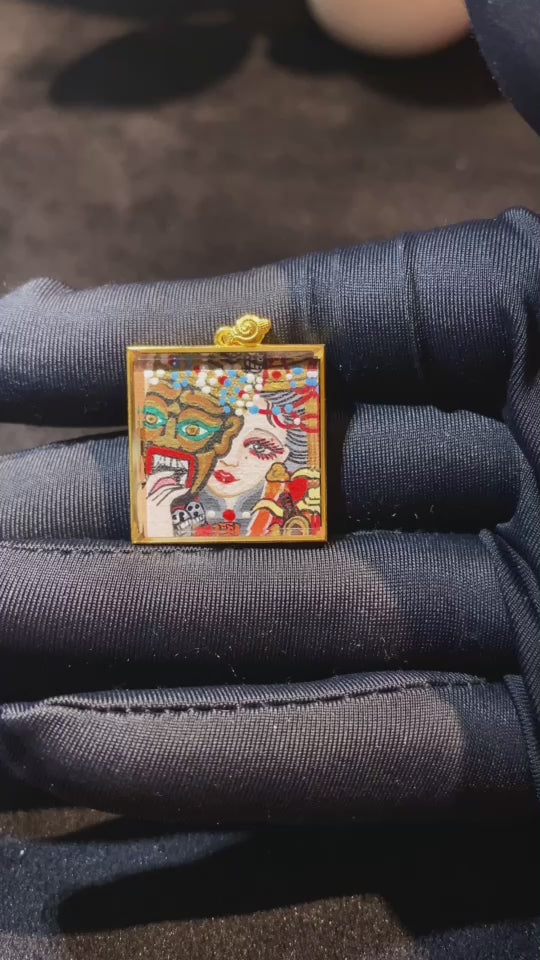 Video showcasing a hand-painted double-sided Zaki Lhamo thangka pendant in an 18K gold gau box, highlighting front deity image, back mantra seed syllable, and fine gold detailing