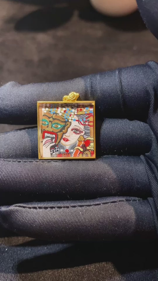 Video showcasing a hand-painted double-sided Zaki Lhamo thangka pendant in an 18K gold gau box, highlighting front deity image, back mantra seed syllable, and fine gold detailing