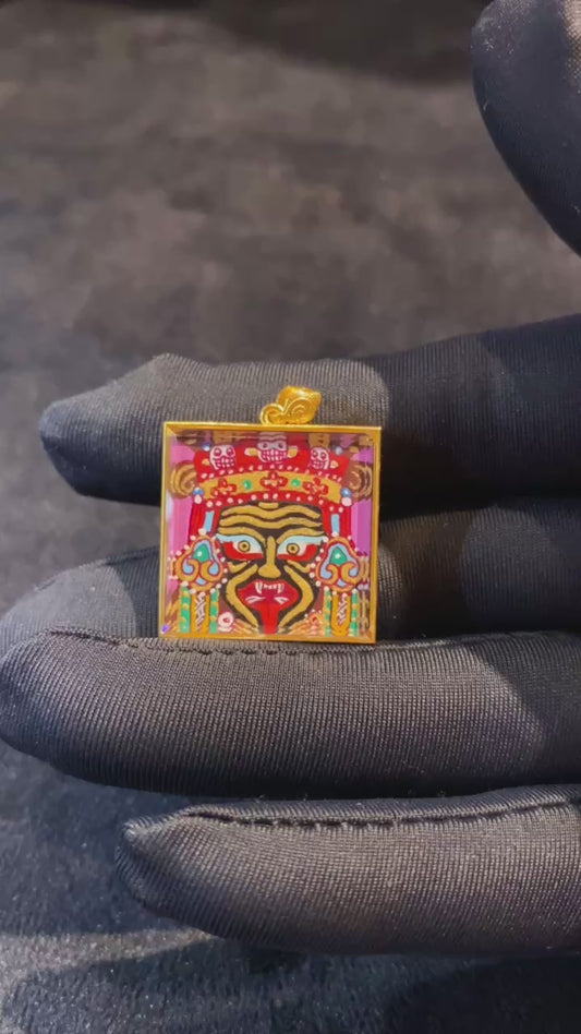 Close-up video of a Zaki Lhamo double-sided Tibetan Thangka pendant, fully hand-painted in 18K gold in the Rebgong tradition, featuring a Gawu box with sapphire crystal and the Zaki mantra seed syllable on the back