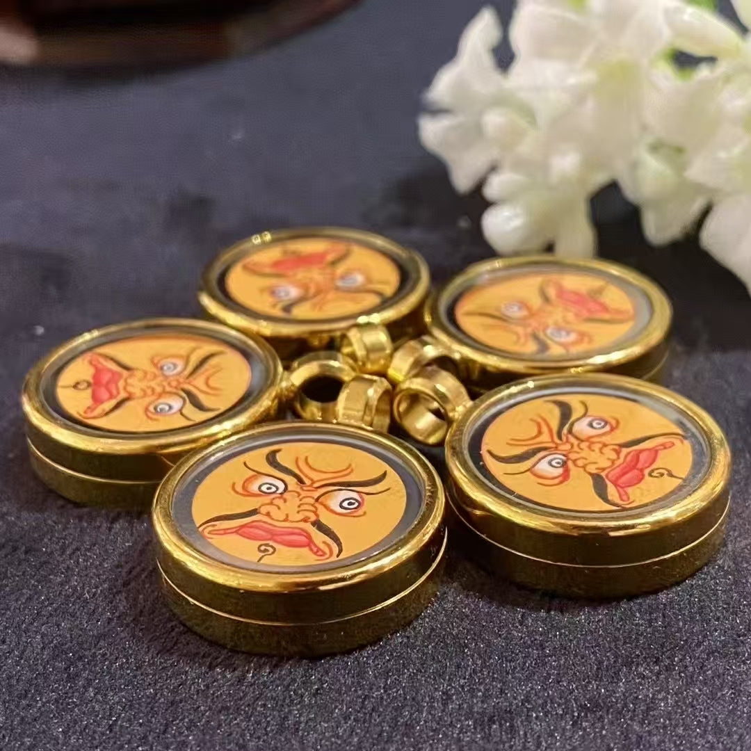 Group display of hand-painted Yellow Jambhala Gawu pendants in titanium steel, Tibetan wealth amulets with consecrated contents